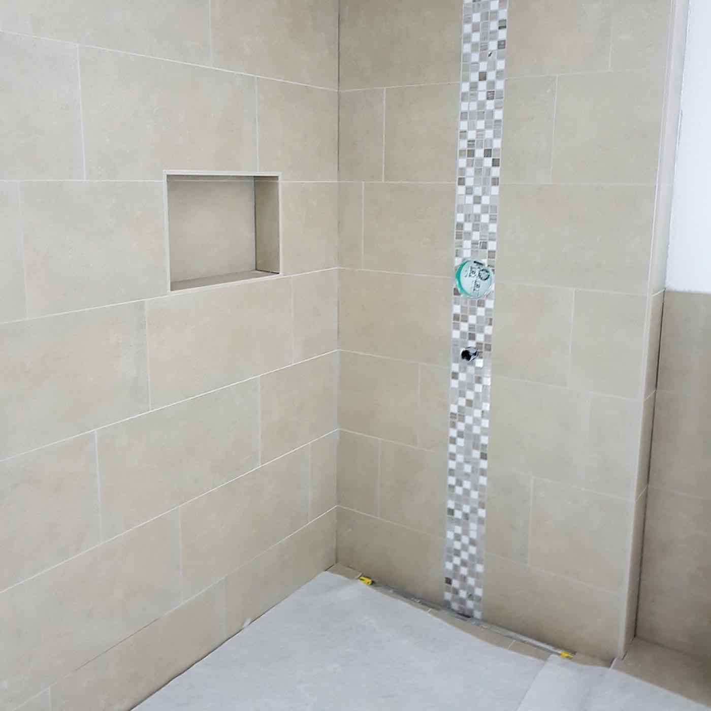 Dusche mit grossen Wandplatten und Mosaikstreifen